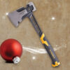 A Roughneck axe with a black and yellow handle lies on a textured brown surface next to a red Christmas ornament and a sparkling diamond ring, with white light streaks adding a festive effect.