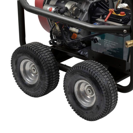 Close-up view of the lower part of a portable generator, showing two large black rubber wheels and part of the engine and frame.
