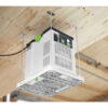 A Festool Air Purifier SYS-AIR M, white and green, is installed upside down on a wooden ceiling using four metal rods in a workshop or garage.