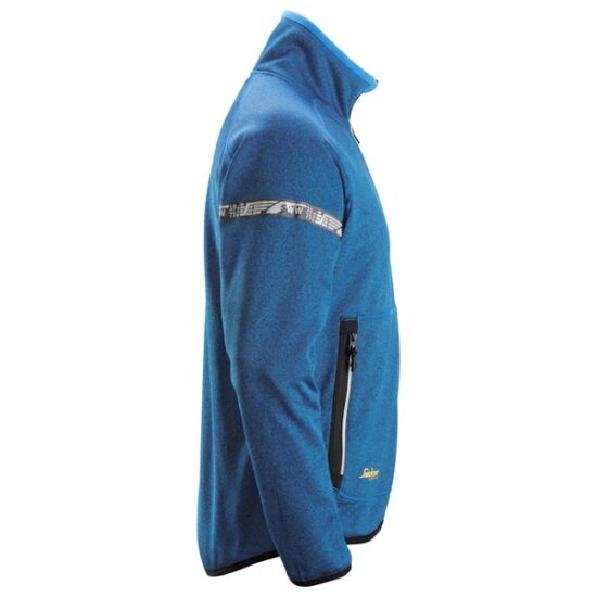 The Snickers 8004 AllroundWork, 37.5® Fleece Jacket in black features a high collar, black zipper pockets, and a patterned stripe across the upper chest and arms. It is displayed on a white background.