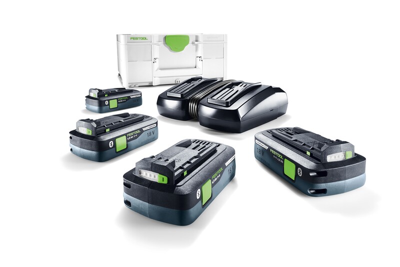 Five Festool 18V rechargeable tool batteries and a dual battery charger are arranged on a white surface, with a white Festool storage case in the background.