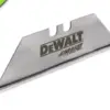 A single DEWALT carbide utility knife blade with sharp edges, a metallic finish, and the DEWALT logo printed on the side. A green label is displayed in the top left corner.