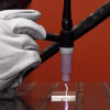 A gloved hand uses the Lorch MicorTIG 200 BasicPlus welding torch, sending a bright spark onto metal in a workshop as a red background highlights the tool’s precision.
