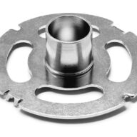 A close-up of a round, silver metallic mechanical component with a central cylindrical hub and multiple cutout sections, set on a white background.