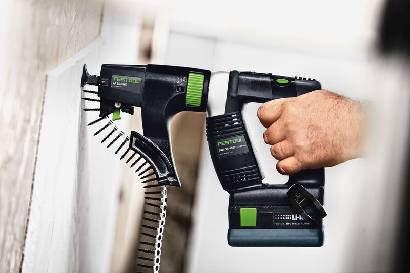 A hand holds a Festool power tool with Festool 769124 Bits PH 2-AF-55 3x against a white surface, while another Festool tool and a strip of collated screws are attached to the wall nearby.