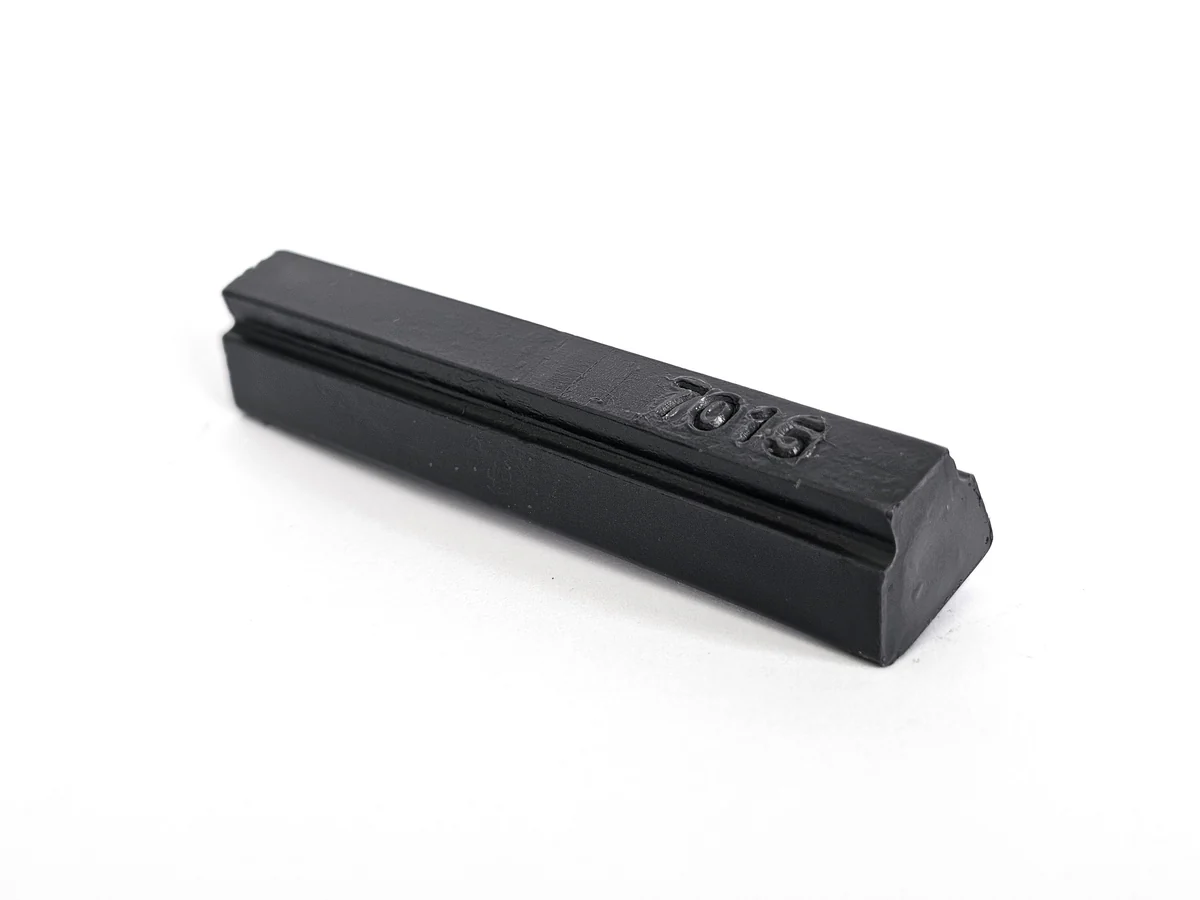 A soft wax slate grey single 7015 rests on a plain white background.