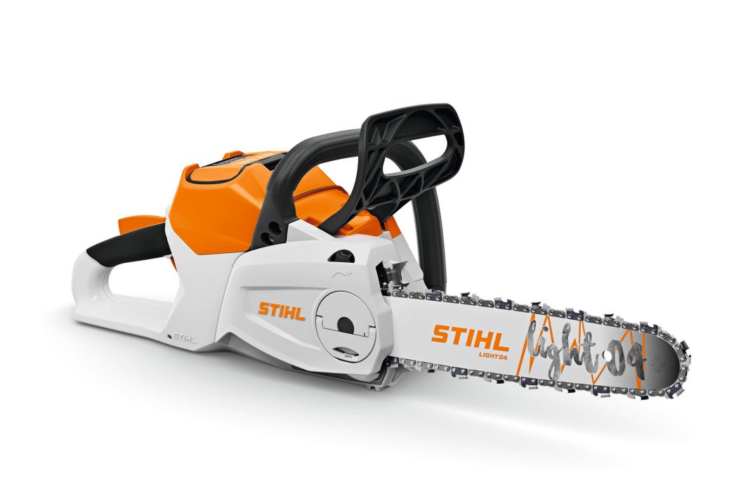 A Stihl battery-powered chainsaw, orange and white, rests on its side with visible cutting chain and bar.