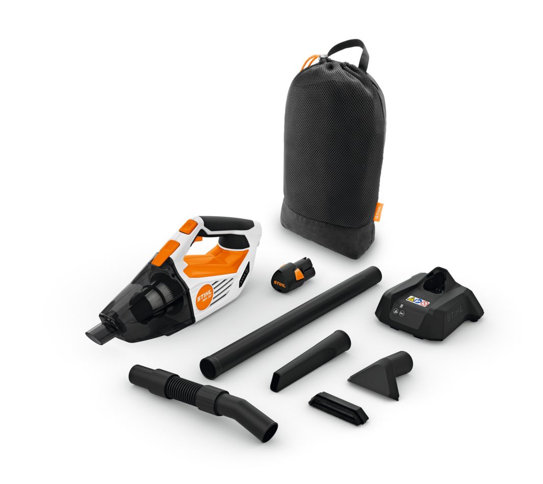 A handheld vacuum cleaner with orange and black accents, attachments, charger, and storage bag are neatly arranged on a white background.