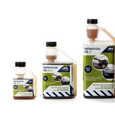 A bottle of Patination Oil 500ml with a white and green label showing buildings and information on preventing patination and lead staining.