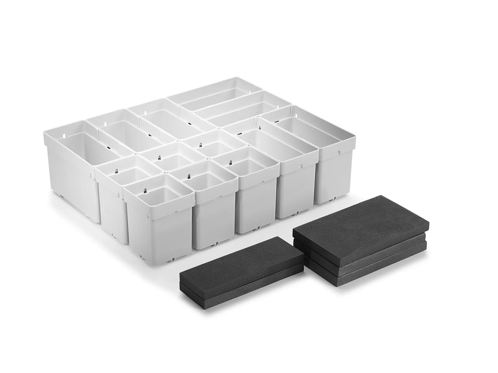 A white plastic drawer organizer with several compartments sits beside stacked black foam pads, all on a plain white background.