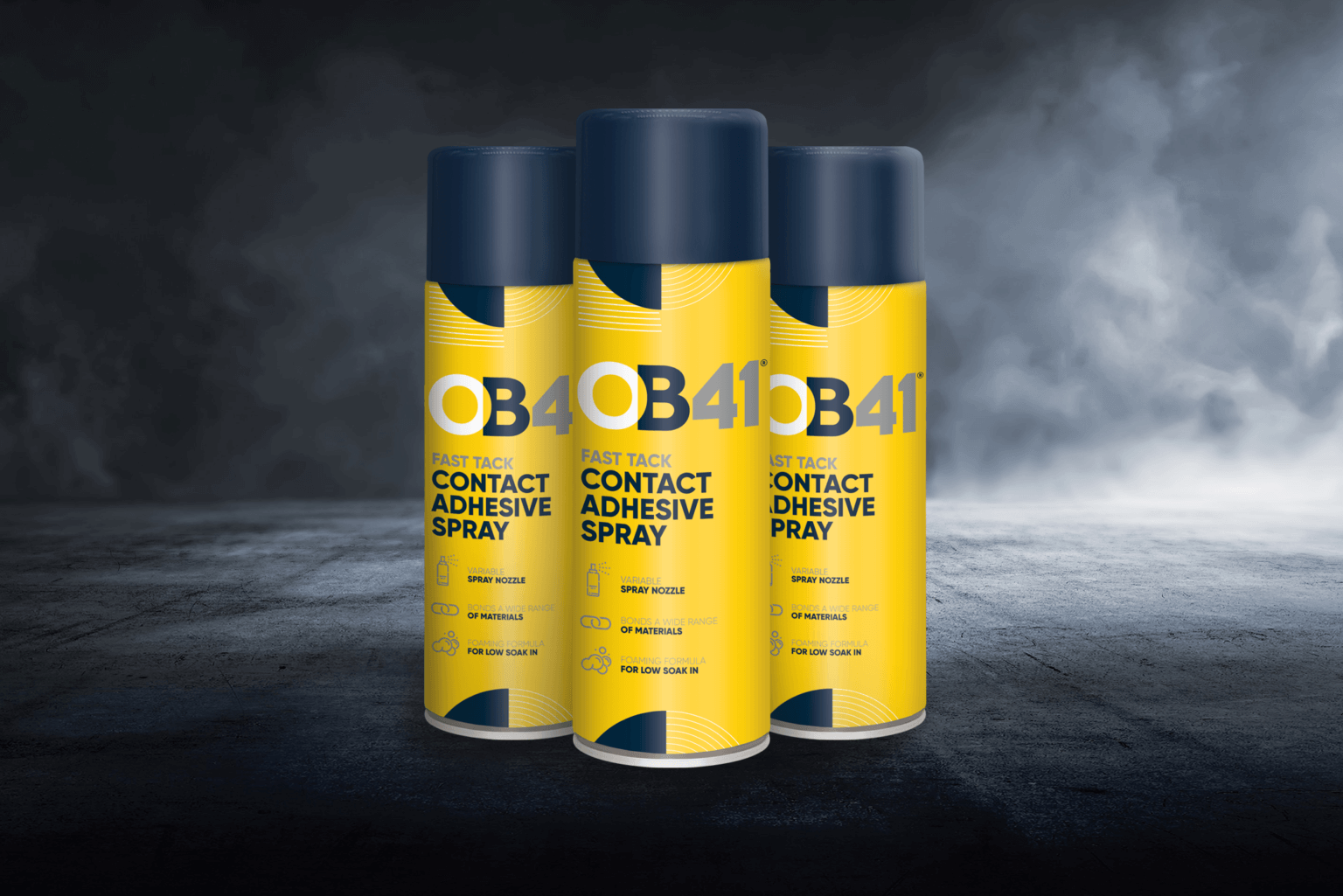 Three yellow and blue OB1 paint remover cans sit on a dark surface with a misty background, featuring bold typography and clear icons.