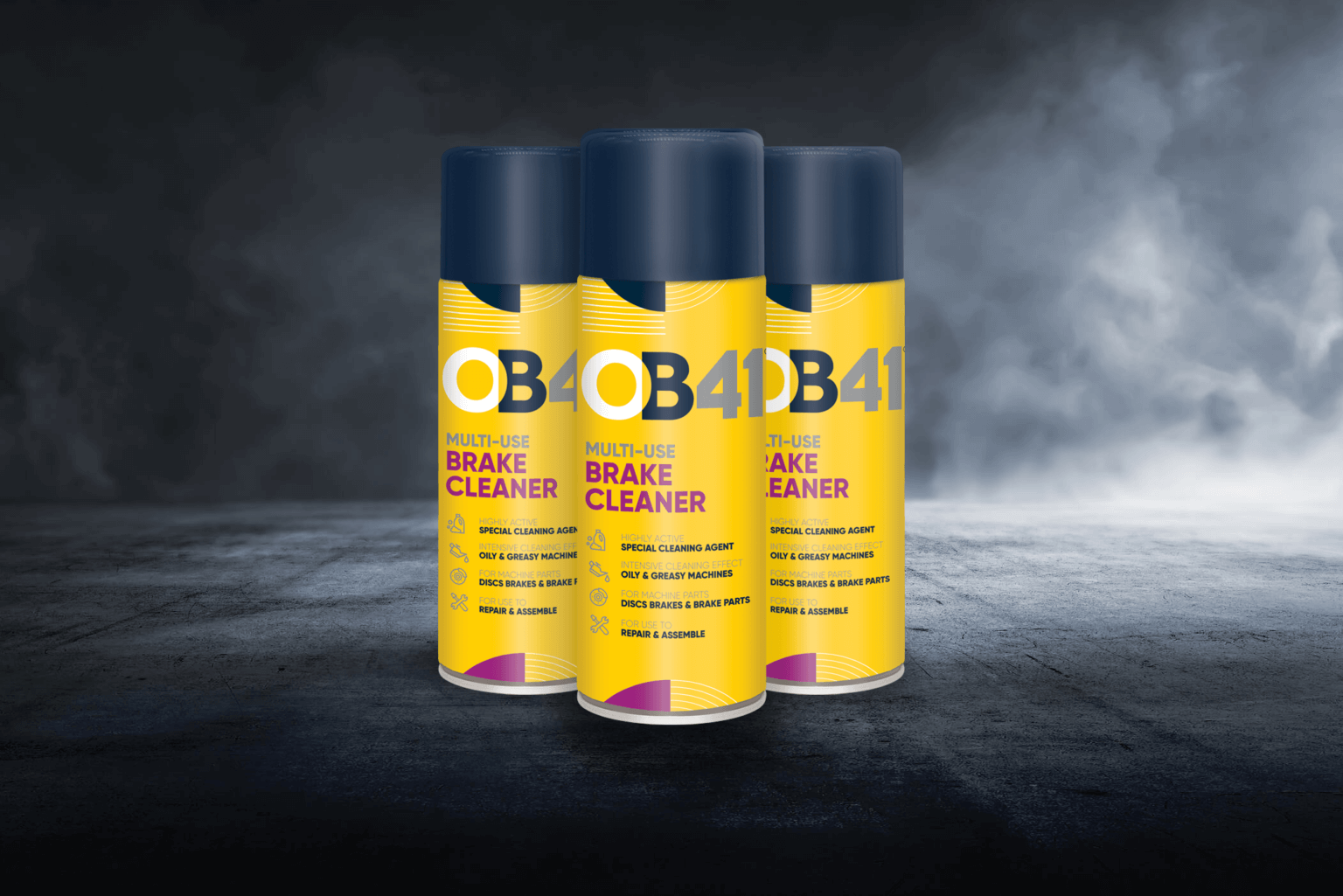 Three yellow and blue OB1 Multi-Layer Paint & Varnish Remover aerosol cans, 500ml, on a dark textured surface with a misty background.