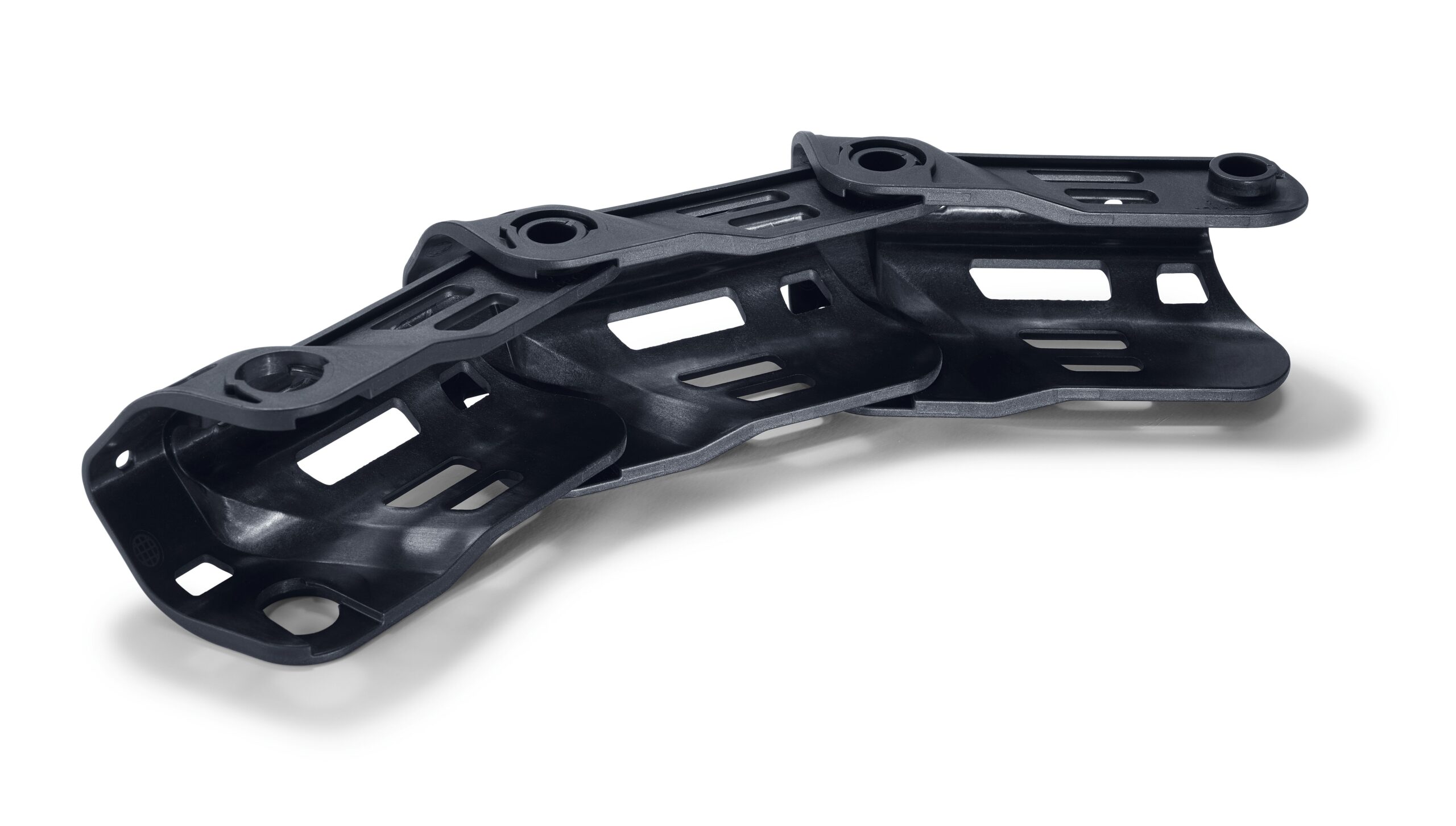 A black, curved, lightweight plastic part with cutouts and mounting holes, possibly for machinery or autos, on a white background.