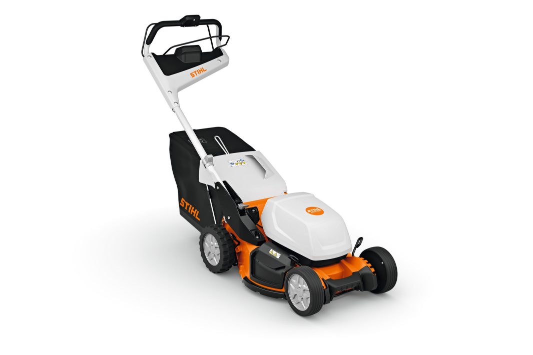The Stihl RMA 750.0 V (AP) lawnmower is white, orange, and black with large rear wheels, handlebar, and rear grass bag on white.