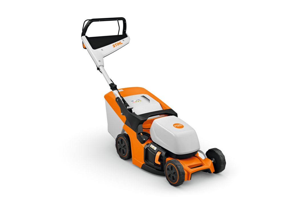 A white and orange Stihl RMA 443.3 (AK) lawnmower with black handlebar, wheels, and rear collection box on a white background.