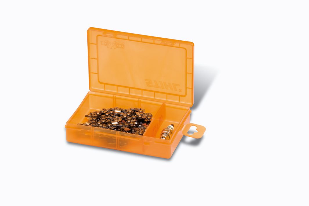 An open orange plastic Stihl case with a transparent lid, holding a coiled saw chain and small round metal parts in a separate compartment.