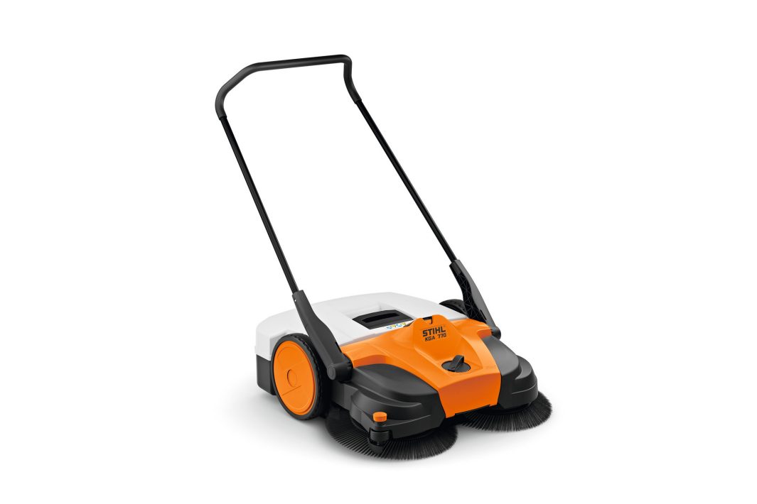 The Stihl KGA 770.0 (AP) Sweeping Machine has orange, white, and black colours, large side wheels, a black handle, and two front rotating brushes.