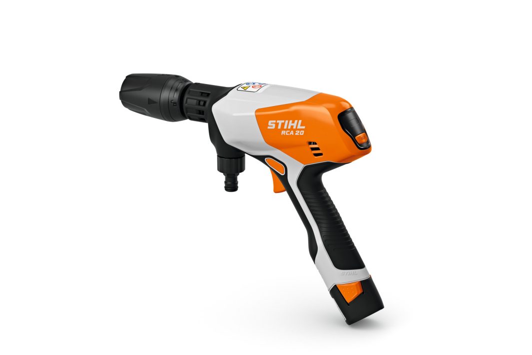 A Stihl RCA 20.0 (AS) Washer with an orange, white, and black pistol-grip body and front nozzle, on a white background.