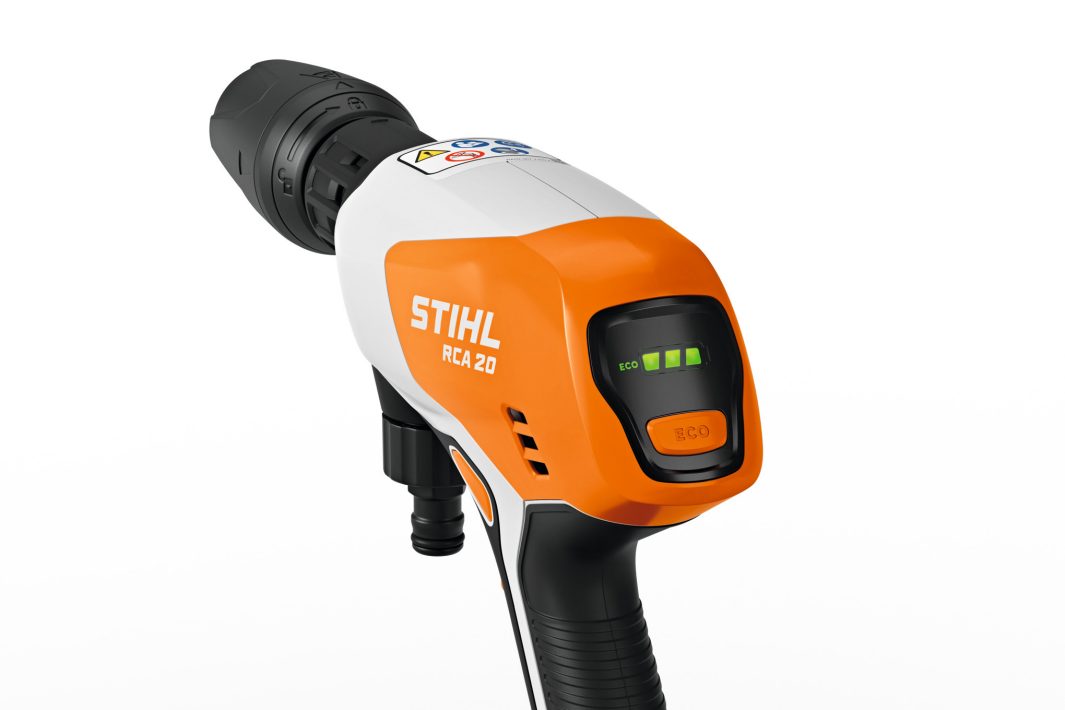 Close-up of a Stihl RCA 20.0 (AS) Washer with orange and white casing, green indicator lights, and an “ECO” button on white background.
