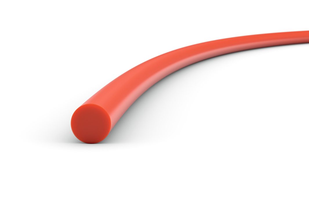 A close-up of a smooth, solid red cylindrical rod or tube, slightly curved and set against a white background.