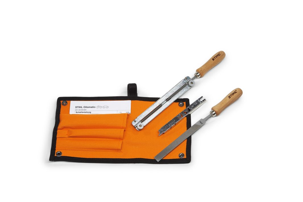 The Stihl .325" Filing Kit features a file and STIHL tool with wooden handles in an orange pouch with three pockets; a white instruction sheet is partly visible in the left pocket.