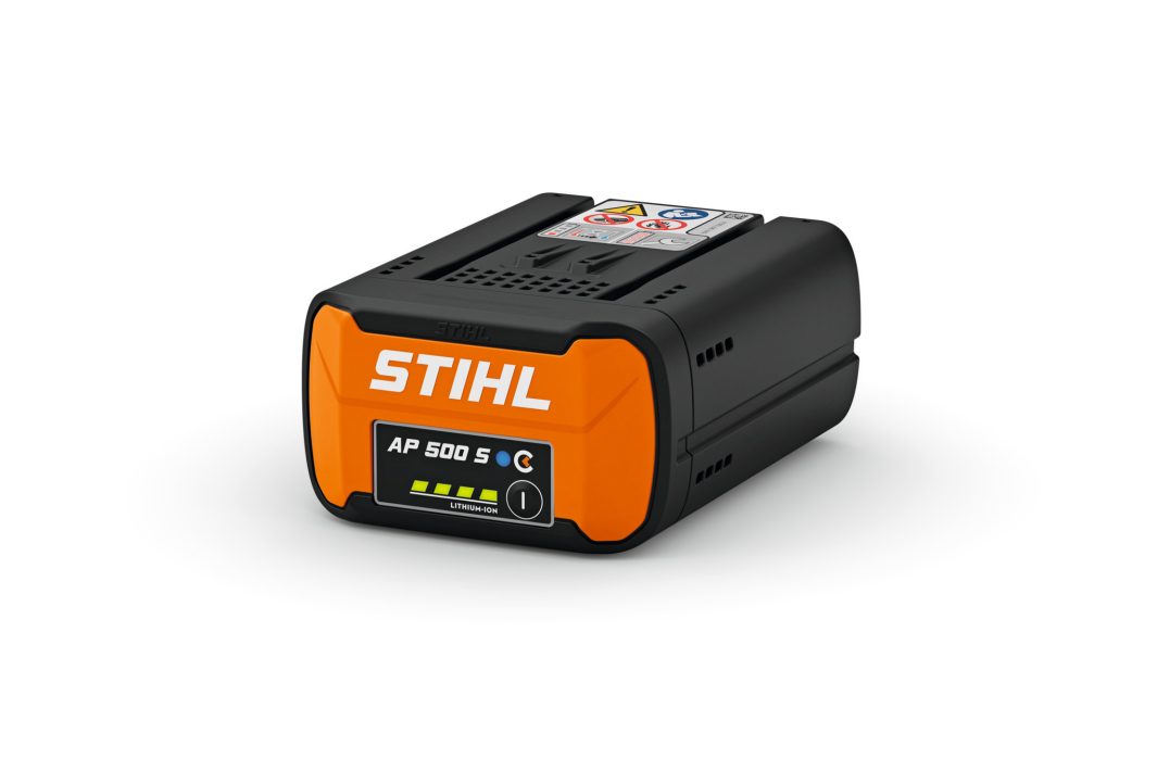 A STIHL AP 500 S lithium-ion battery with an orange front, charge indicator lights, and warning label on top on a white background.