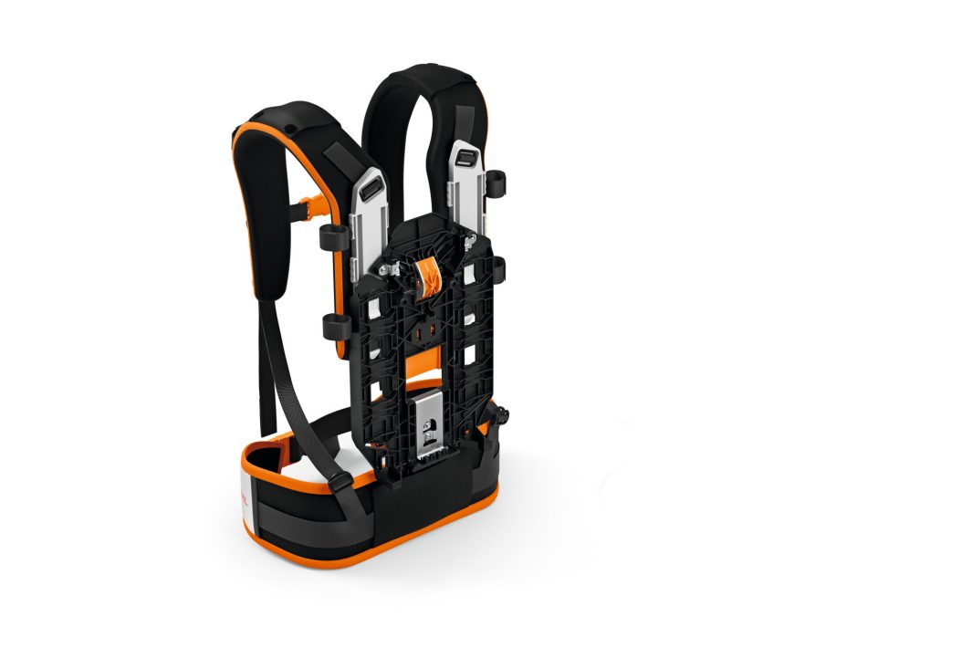 A black and orange wearable rucksack frame with padded straps, metal supports, and adjustable back panel for heavy equipment.