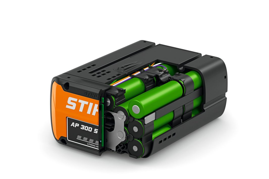 A STIHL AP 300 S lithium-ion battery pack is partially opened, revealing green cylindrical cells and internal wiring on a white background.
