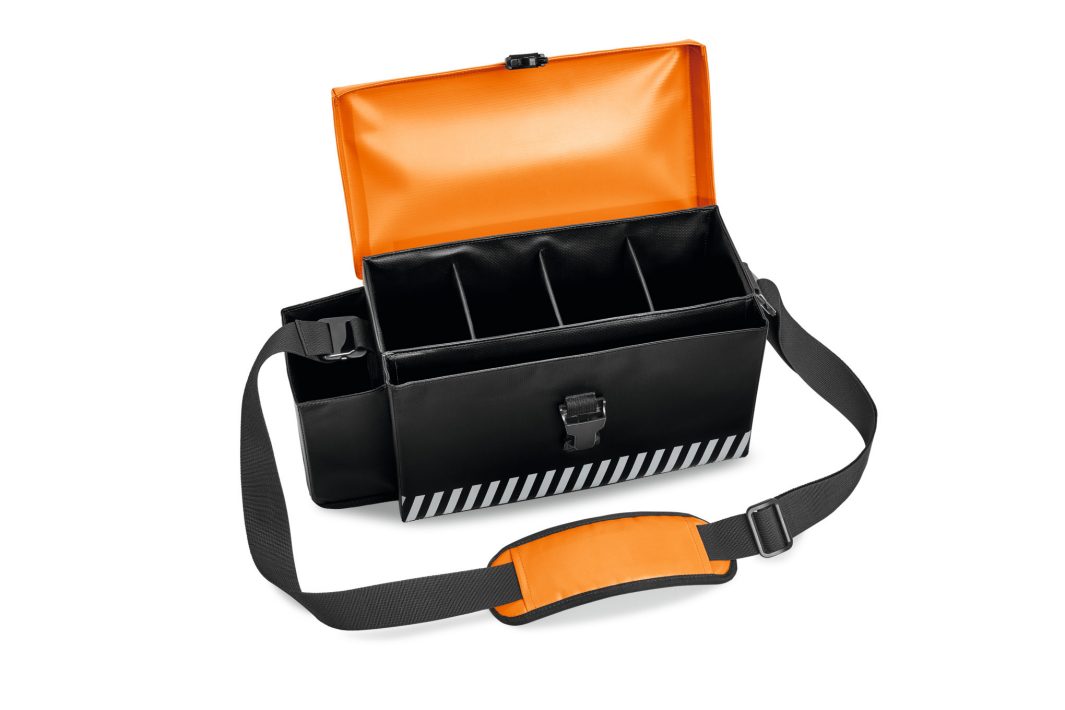 A black and orange rectangular carrying case with an adjustable shoulder strap, open to four compartments, striped bottom, and front catch.