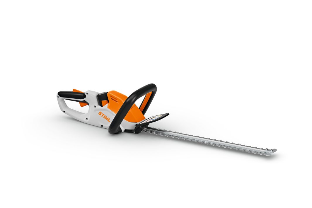 The Stihl HSA 40 (AS) hedge trimmer has a long 20" blade and guard, orange, white, and black body, on a white background.