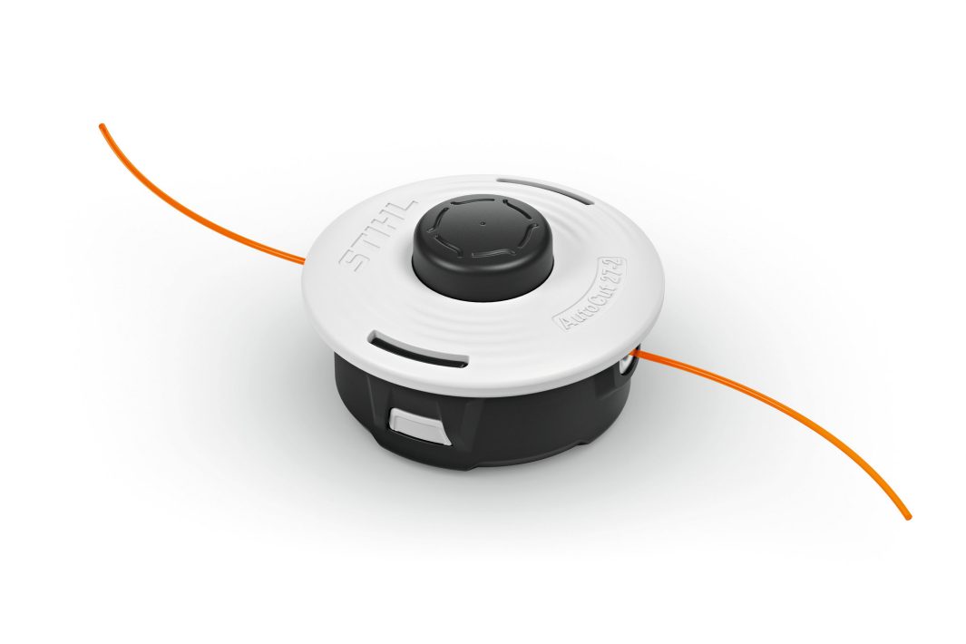 A black and white STIHL AutoCut 27-2 strimmer head with orange nylon lines extending from both sides, for grass trimmers and brushcutters.